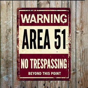 Vintage-style Area 51 Warning No Trespassing metal sign in red and cream mounted on wooden wall – alien UFO decor for indoors or outdoors.
