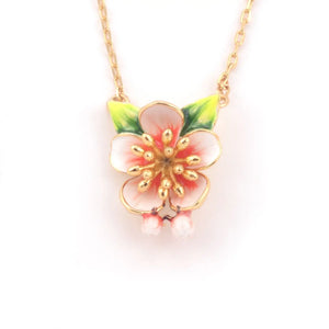 Close-up of Bill Skinner Apple Blossom Pendant showing hand-painted enamel flower with pink and white petals, gold-plated details, green leaves, and hidden mouse charm.