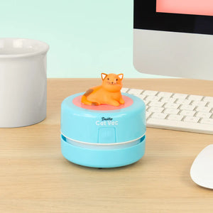 Cat Vac desktop vacuum cleaner placed on office desk beside keyboard and monitor, ready for cleaning.