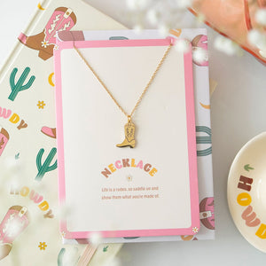 Front view of the Cowboy Boot Necklace on a greeting card with a pink border.
