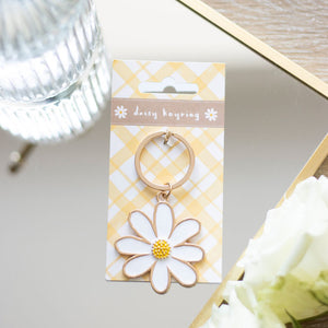 Daisy Flower Enamel Keyring on a yellow gingham backing card, featuring a white daisy with gold-tone detailing.