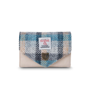Front view of a small Harris Tweed purse with a blue and grey tartan flap, soft cream body, and Islander metal crest detail.