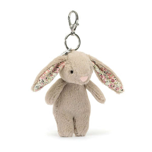  Spring has sprung! The Blossom Beige Bunny Charm boasts floral ears & a fluffy tail. Clip this soft pal onto your bag for a touch of whimsical charm.