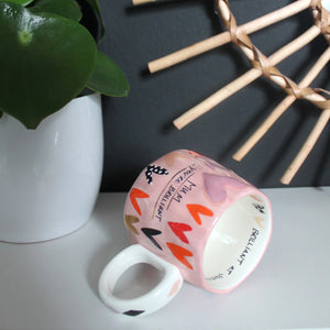 Mug on its side showing inside and handle – Mug lying on its side revealing interior message and wide round handle.