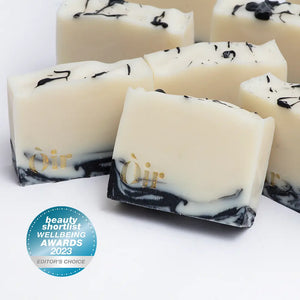 Handmade Òir rosemary ho leaf geranium soap bar with charcoal swirls and gold logo.