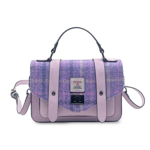 Front view of Islander mini satchel with purple and pink Harris Tweed flap, pale lilac faux leather trim, and top handle with crossbody strap.