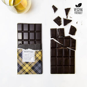Vegan-friendly Dram of Whisky dark chocolate bar with rich 58% Belgian chocolate and Scotch whisky, wrapped in yellow tartan paper with a dram on the side.