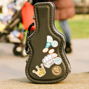 Black guitar case lunch box decorated with custom stickers.