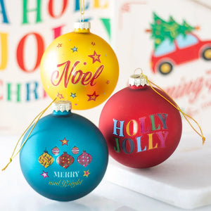 Yellow, red, and teal nostalgic glass Christmas baubles with Holly Jolly, Noel, and Merry & Bright designs.