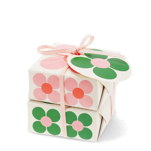 Front view of soap gift set wrapped in pink and green daisy paper with bow.