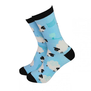 Blue bamboo socks featuring a playful black and white sheep pattern, with black toe, heel, and cuff detailing, shown from a side angle on a white background.