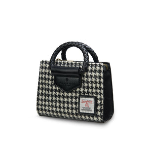 Angled: The Mini Arran Tote with Black & White Dogtooth Harris Tweed® with a black PU leather & braided handle.