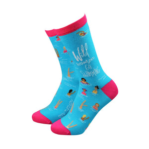 Bright turquoise women’s bamboo socks with pink accents, featuring swimmers and the text “Wild Women Go Swimming” – fun sustainable sock design.