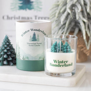 Winter Wonderland candle with 3D tree scene in glass jar beside matching gift box, styled on marble with festive décor.