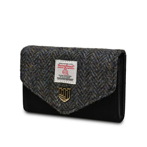 Side view of black and grey herringbone Harris tweed and suede small purse.