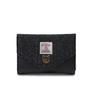 Front on image of the Black Herringbone Harris Tweed Purse. It has the authentication label displayed on the front and is closed. 