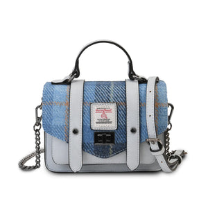 Harris Tweed handbag made with blue synthetic leather and finished with a blue tartan fabric. The mini handbag has an adjustable strap which has been drapped across the top.