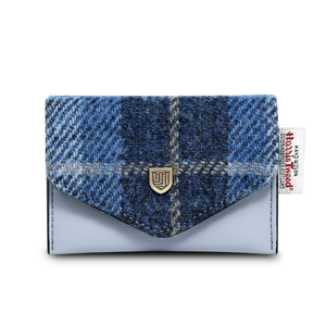 Card holder purse made from blue synthetic leather and blue tartan Harris Tweed. The Harris Tweed authenticity label can be seen on the right hand side of the purse. 
