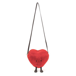 Hanging from the shoulder strap the Jellycat Heart Shaped Bag. 