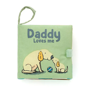 Soft crinkle cover children’s book from Jellycat called “Daddy Loves Me”. It has the picture of an adult dog and a baby bog sitting facing each other. 