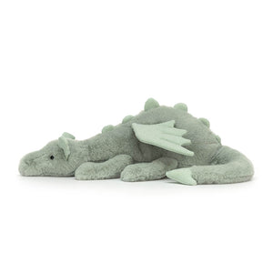 Jellycat Sage Dragon children’s soft toy lying to the side. Covered in mint green fut with soft wings and a long tail.