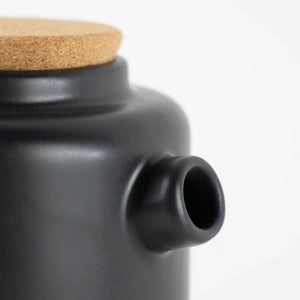 Close up image of the ceramic teapot in Matt black showing the spout and cork lid. 