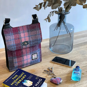 A pink and blue tartan Maccessori Harris Tweed Satchel shoulder bag sitting on a table top.