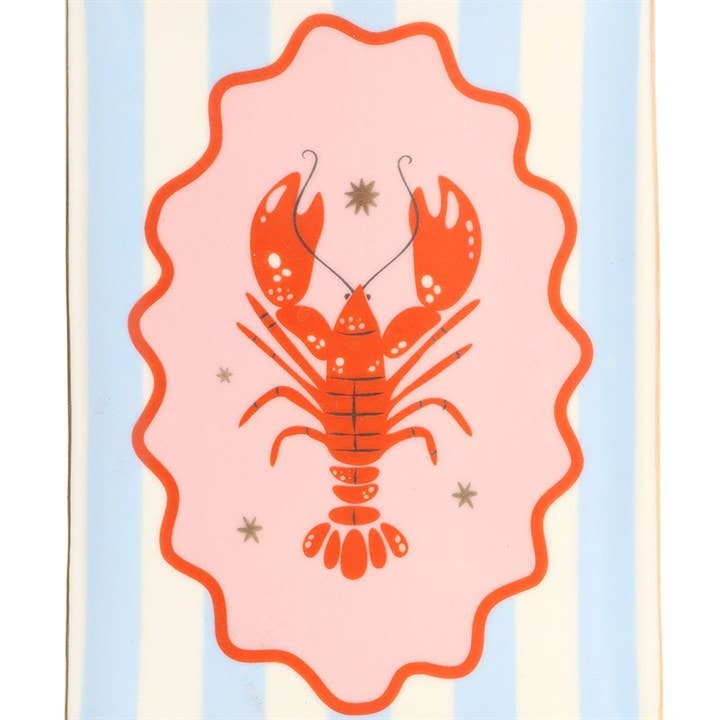 Side angle of coastal striped trinket dish with lobster motif