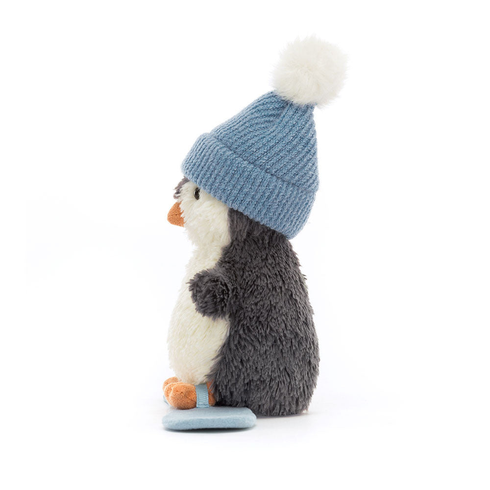 Side view of Jellycat Peanut Penguin Snowboarding plush toy showing soft grey fur and blue hat.
