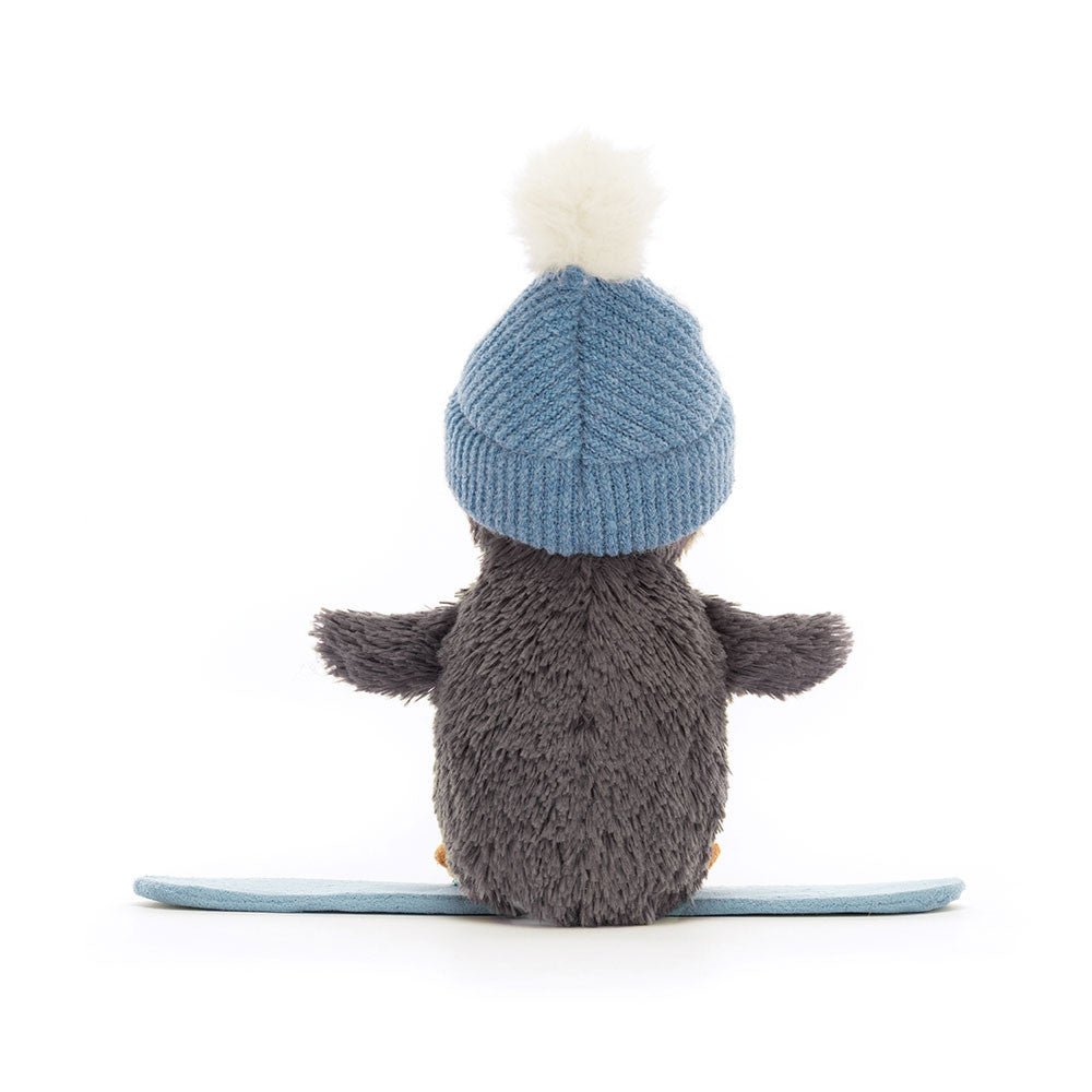 Back view of Jellycat Peanut Penguin Snowboarding with white pom-pom hat and blue snowboard.