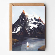 Greeting card featuring an illustrated Norwegian mountain scene with a lone sailboat on icy water and snow-capped peaks, paired with a kraft envelope.