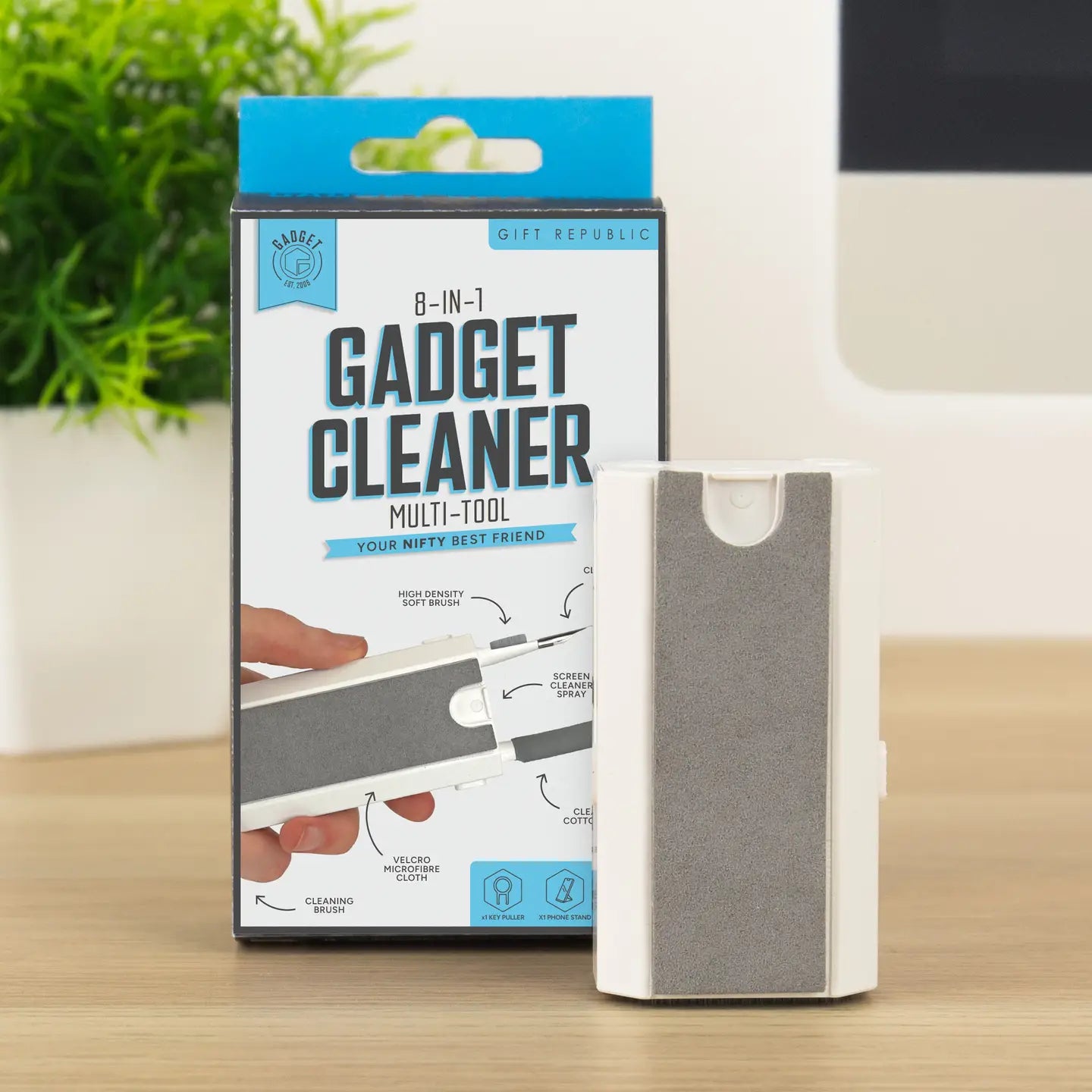 8-in-1 gadget cleaner multi-tool in retail packaging on desk.