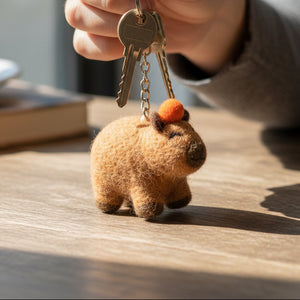 Handmade brown wool felt capybara keyring with stitched facial features