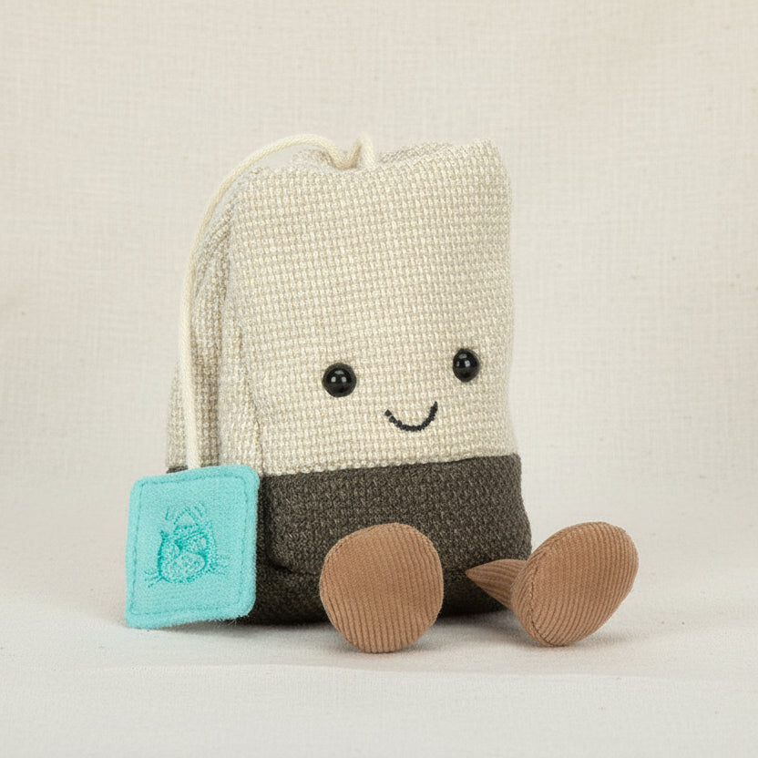Jellycat Amuseables Steepy Tea Bag sitting upright with turquoise tag