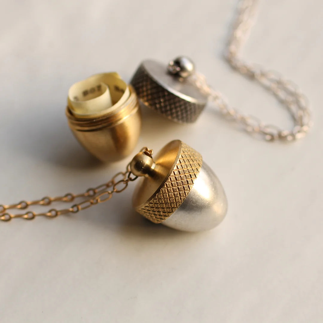 Two Acorn Locket Necklaces in gold and silver tones, one opened to reveal a rolled-up hidden message.