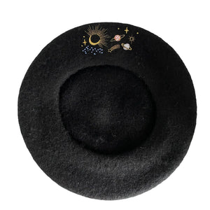 Top view of black wool beret with colourful embroidered space-themed design.