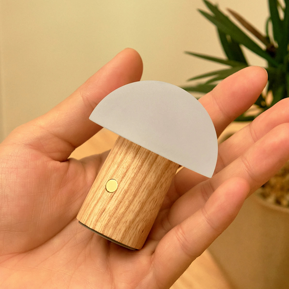 Unlit Alice Mushroom Lamp Super Mini with frosted white shade held in hand.
