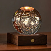 Solar Amber Crystal Light featuring 3D laser-engraved solar system design on a wooden base, glowing with warm amber light.