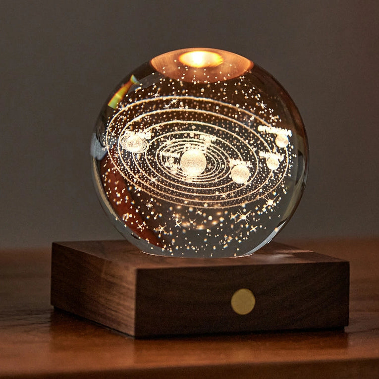 Solar Amber Crystal Light featuring 3D laser-engraved solar system design on a wooden base, glowing with warm amber light.