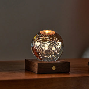Solar Amber Crystal Light featuring 3D laser-engraved solar system design on a wooden base, glowing with warm amber light.