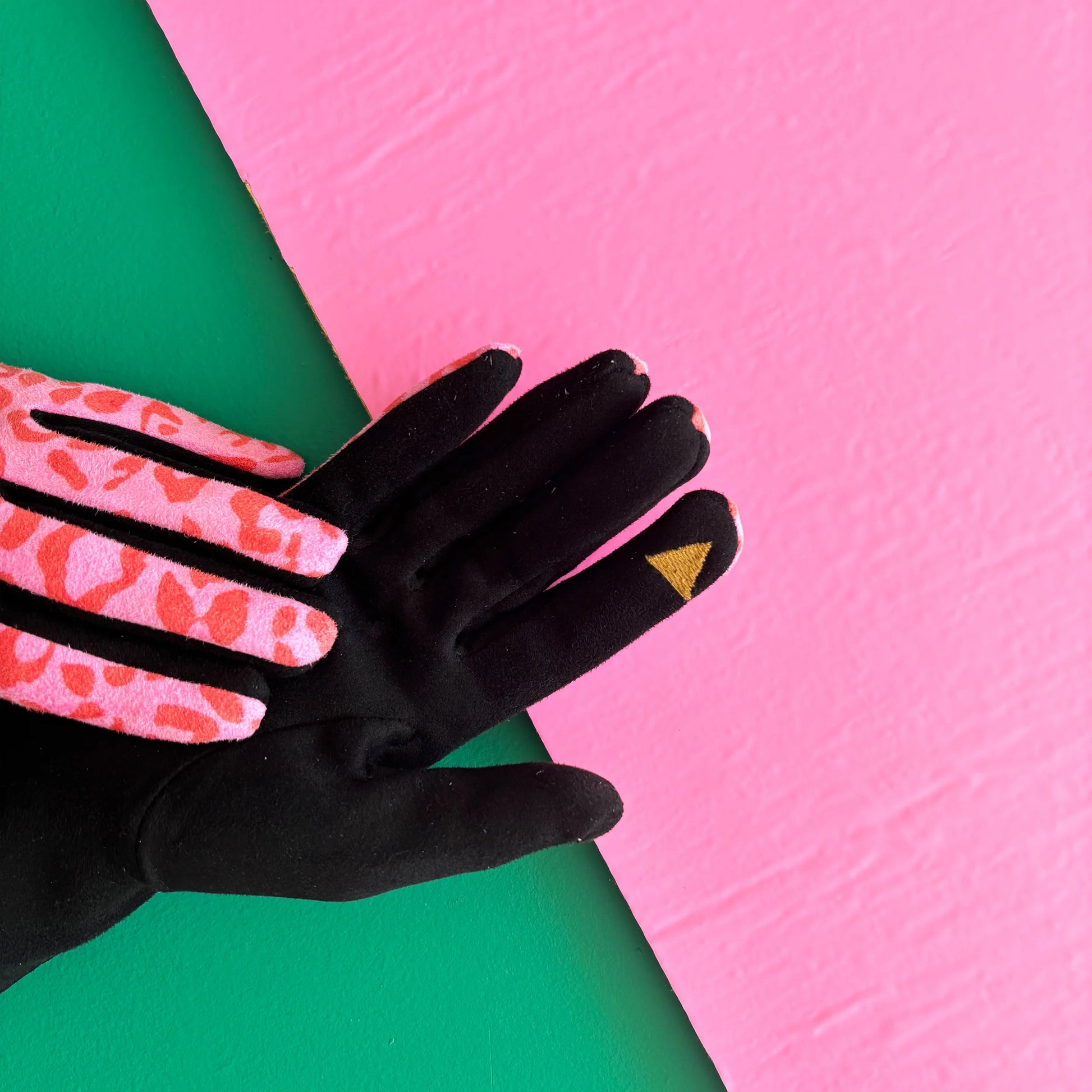 Black suedette gloves with touch-screen friendly fingertip and pink leopard print detailing shown on palm side.