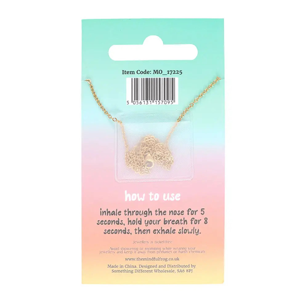 Back of anti-anxiety necklace packaging showing breathing instructions and coiled gold chain, emphasising stress relief and calming techniques.