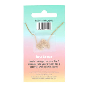 Back of anti-anxiety necklace packaging showing breathing instructions and coiled gold chain, emphasising stress relief and calming techniques.