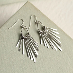 Pair of sterling silver art deco fringe earrings with cascading bar details, arranged in a diamond shape and displayed on a textured light grey box.