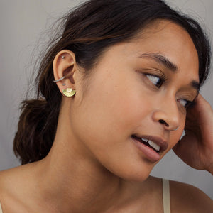 A model wearing the gold Art Deco stud earrings, showcasing their elegant geometric design and how they sit comfortably on the earlobe.