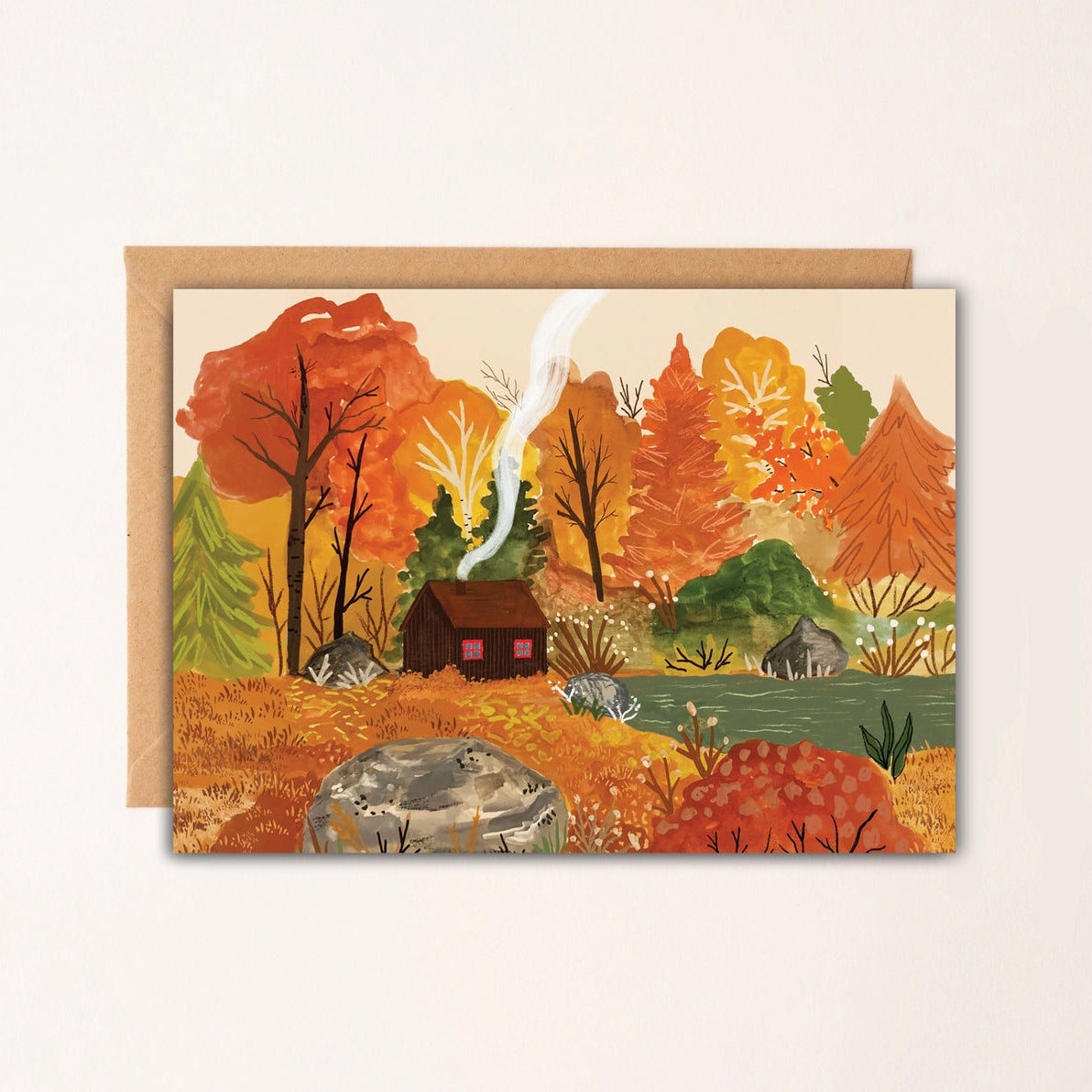 Autumn Cabin Card featuring illustrated woodland cabin with smoke rising and autumn trees, printed on luxury uncoated card with Kraft envelope.
