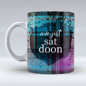 Side angle of Ave Jist Sat Doon Mug featuring bold lettering on a colourful ceramic cup.
