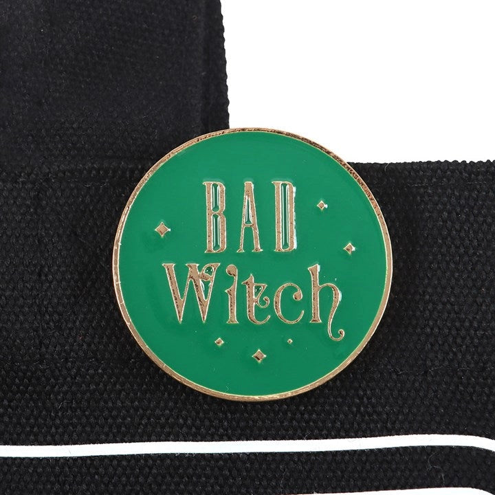 Enamel “Bad Witch” pin badge in green and gold.