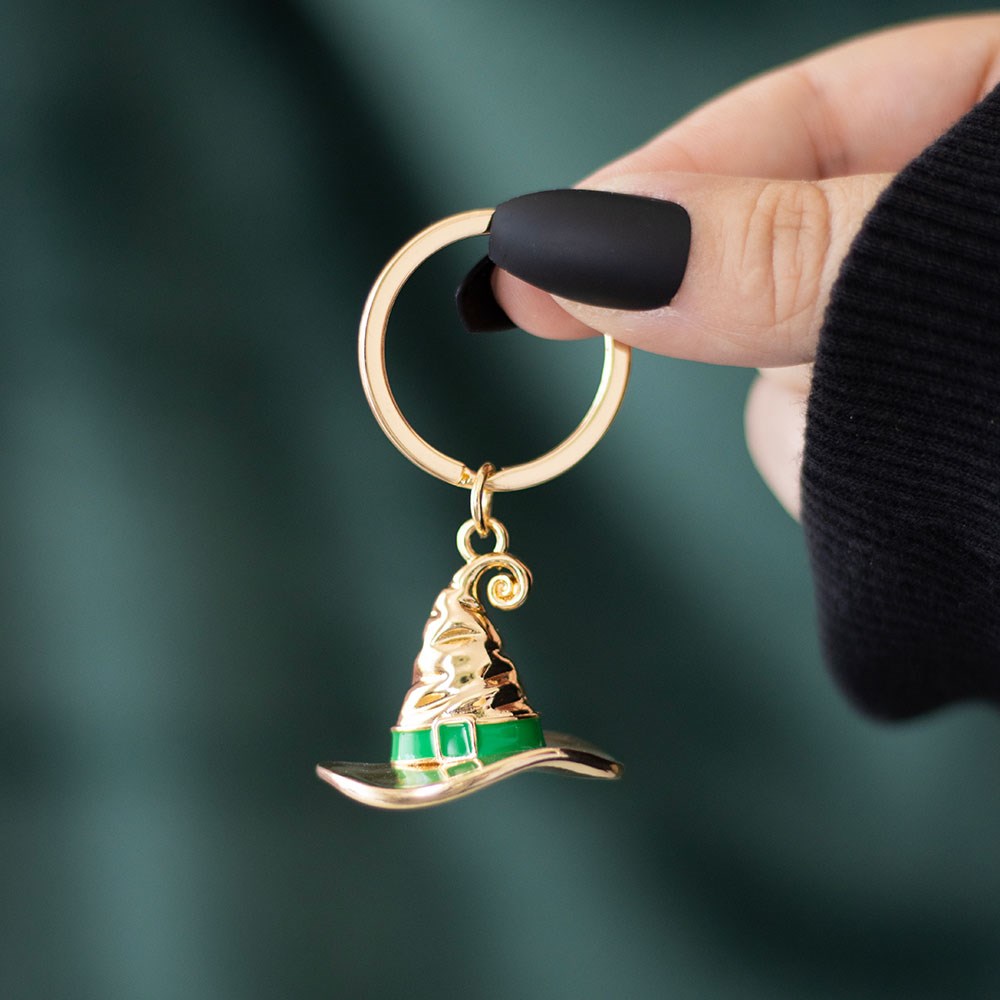 Gold Bad Witch Social Club witch hat keyring close-up.