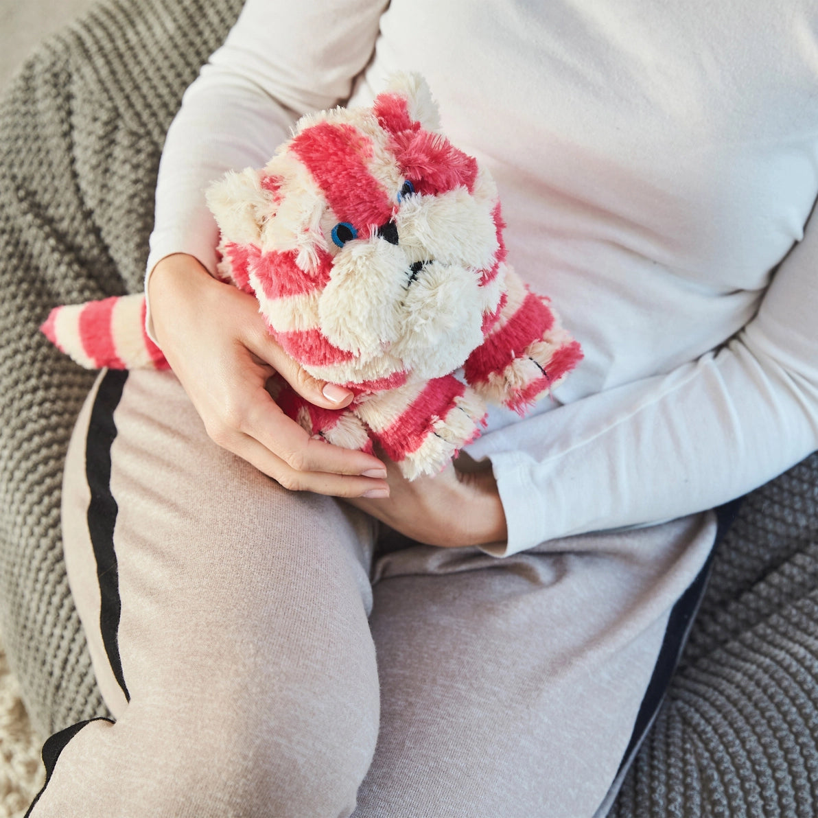 Woman holding Warmies Bagpuss Cat heatable lavender toy.